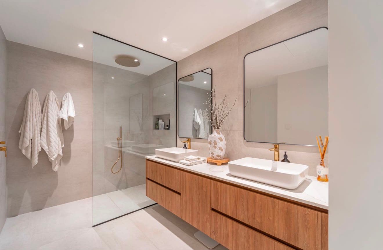 Renovated bathroom with a frameless walk-in shower, timber double vanity and brushed brass fittings