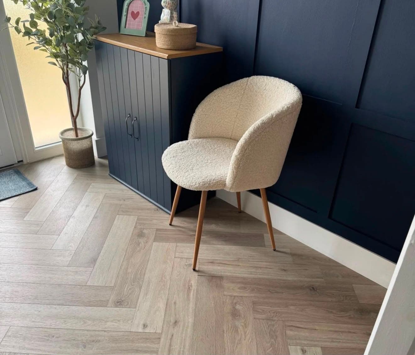Hallway with herringbone wood-effect flooring and a navy paint-finished panelled wall