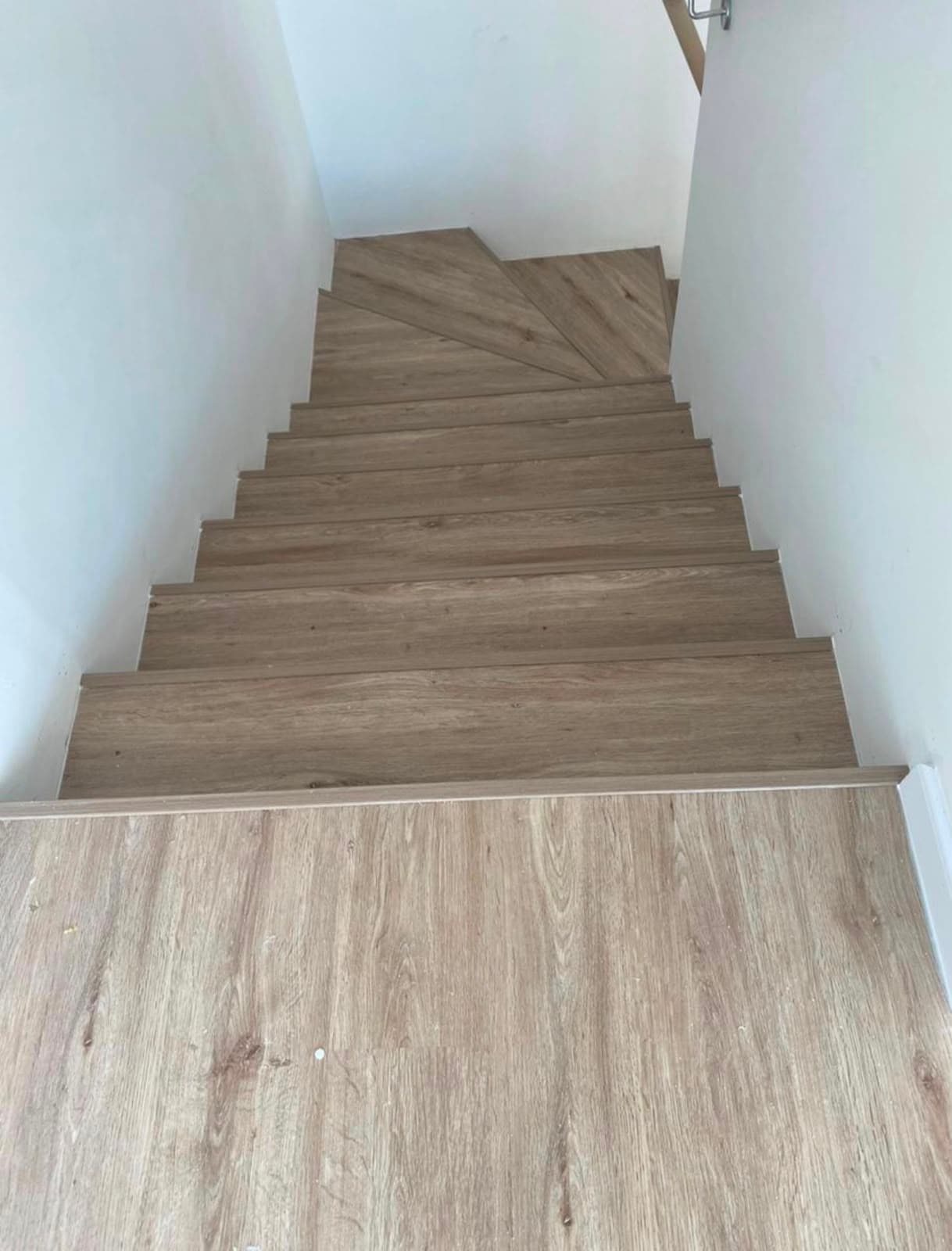 Wood-effect flooring laid across staircase treads and the landing below