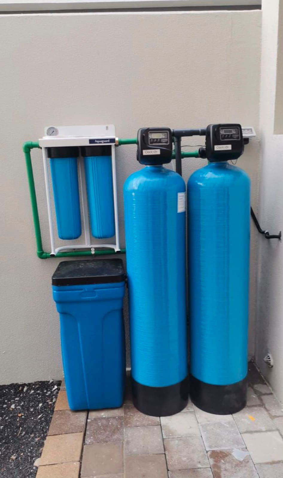 Installed whole-house water filtration system with twin pressure vessels, a softener and jumbo pre-filters
